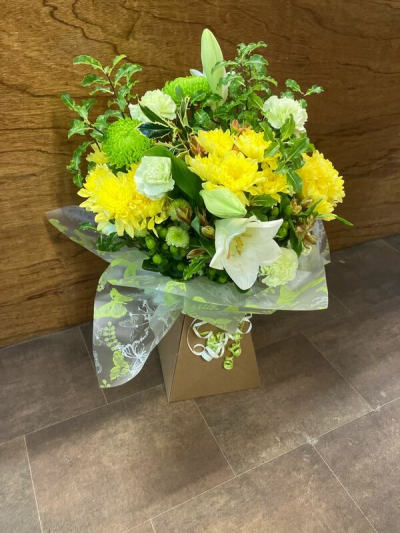 Lemon Meadow Glow - A bright and refreshing arrangement filled with cheerful yellow tones and crisp greenery. The sunny palette brings a sense of warmth and positivity, while the soft whites add balance and elegance. Designed with a natural, garden-inspired flow, this piece feels light, uplifting, and full of life. Perfect for celebrations or simply brightening someone’s day, it radiates happiness, freshness, and effortless charm.