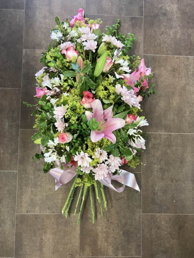 Tied Sheaf - A graceful tied sheaf arrangement in soft pink and pastel tones, beautifully accented with fresh seasonal greenery and delicate textures. Designed to lay naturally, this elegant tribute offers a heartfelt expression of love, remembrance, and gentle sympathy for a cherished loved one.